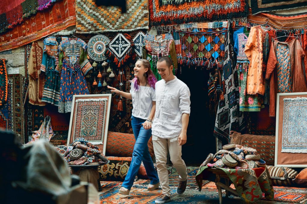 Couple in love walks and hugs at the Eastern carpet market. A man and a woman choose Turkish carpet